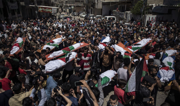 Палестинцы на похоронах двух женщин и восьми детей из семьи Абу Хатаб в городе Газа, которые были убиты в результате авиаудара Израиля, 15 мая 2021