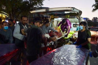Медики и раненый мужчина после взрыва в Кабуле, 26 августа 2021 года 