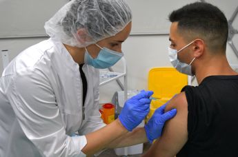 Медицинская сестра делает посетителю прививку в пункте вакцинации от Covid-19
