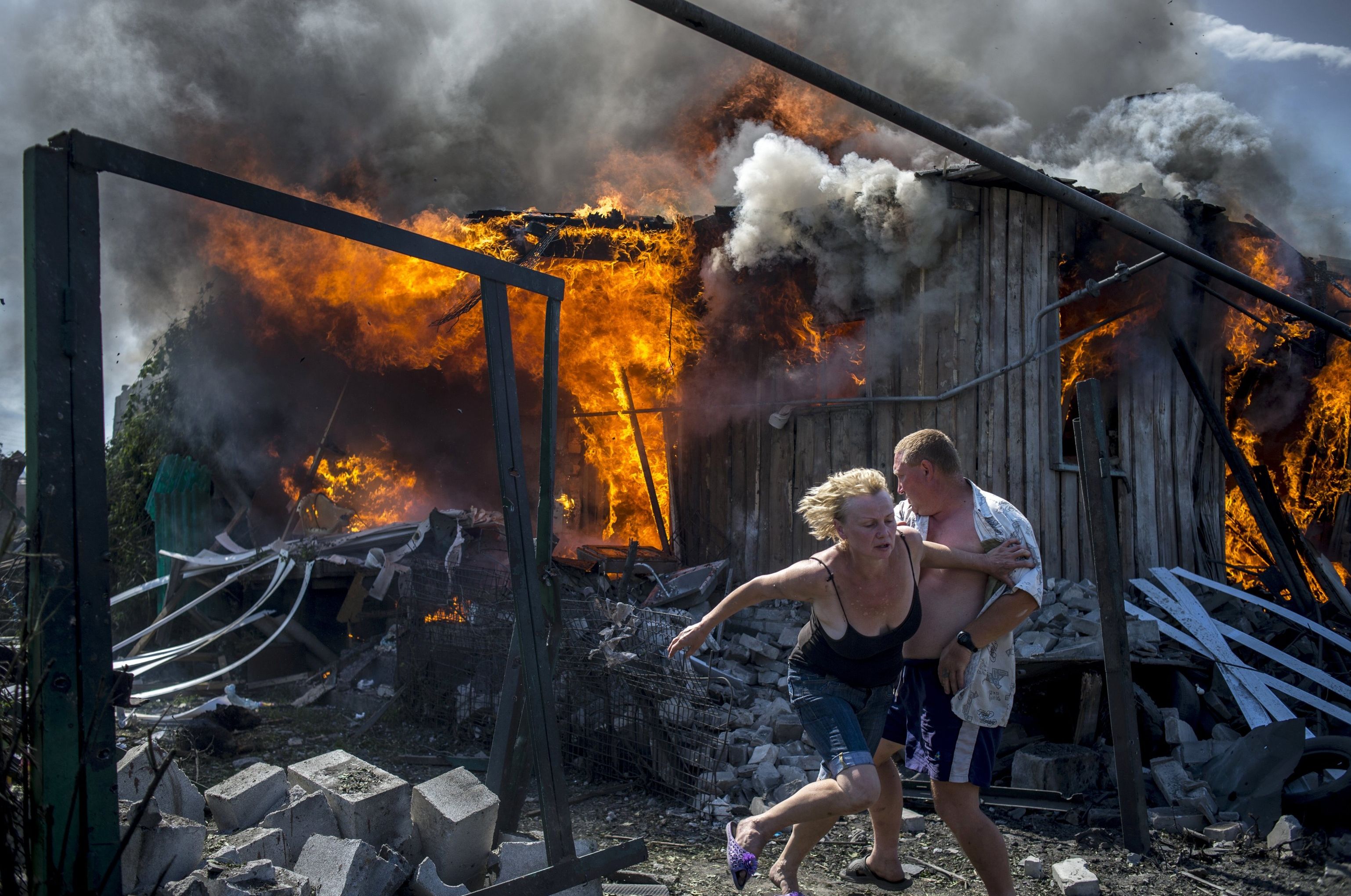 Местные жители спасаются от пожара, возникшего в результате авиационного удара вооруженных сил Украины по станице Луганская, 2014 год