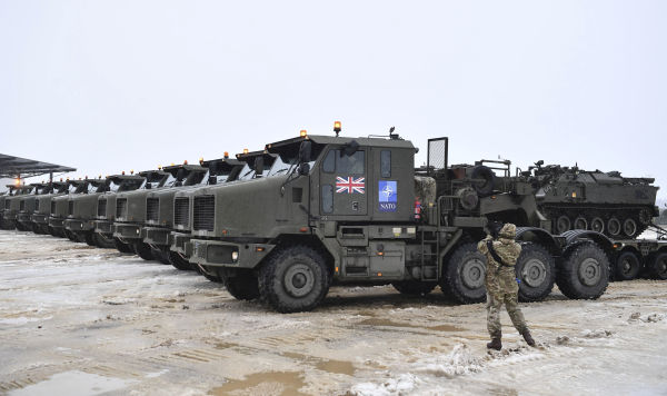 Танки, загруженные на платформы военных грузовиков в составе дополнительных британских войск и военной техники, прибывают на эстонскую базу боевой группы НАТО в Тапе, Эстония, 25 февраля 2022