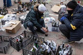 Люди готовят коктейли Молотова в Киеве, Украина, 27 февраля 2022 года
