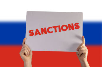 Табличка "Санкции" на фоне флага России