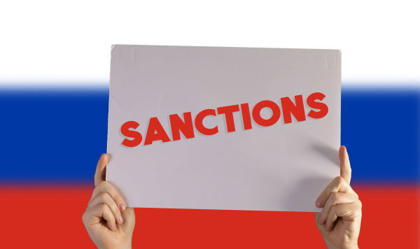 Табличка "Санкции" на фоне флага России
