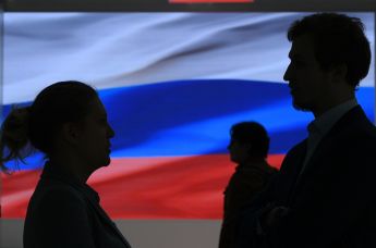 Силуэты людей на фоне флага России