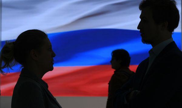 Силуэты людей на фоне флага России