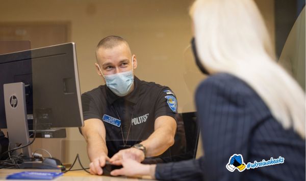 Сотрудник службы Департамента полиции и погранохраны работает с документами беженцев из Украины
