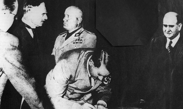Рейхсканцлер Германии Адольф Гитлер подписывает Мюнхенское соглашение 1938 года о разделе Чехословакии.