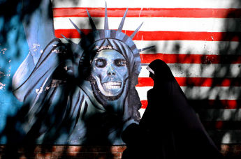 Женщина проходит мимо граффити с изображением статуи Свободы США, нарисованной на стене бывшего посольства США в Тегеране, Иран. Архивное фото