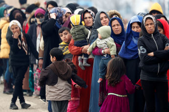Мигранты стоят в очереди, чтобы получить продовольственную помощь на турецком пограничном пункте Пазаркуле в Турции, 5 марта 2020 года