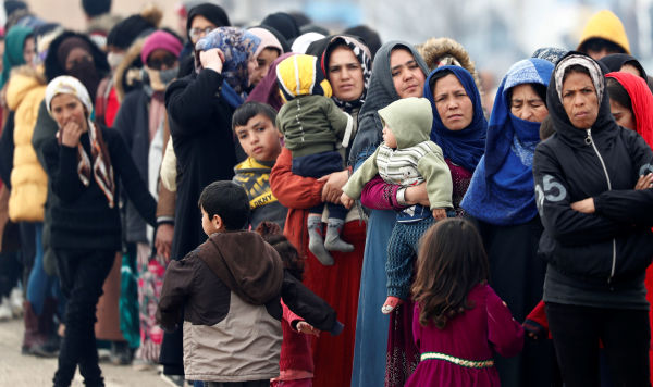 Мигранты стоят в очереди, чтобы получить продовольственную помощь на турецком пограничном пункте Пазаркуле в Турции, 5 марта 2020 года