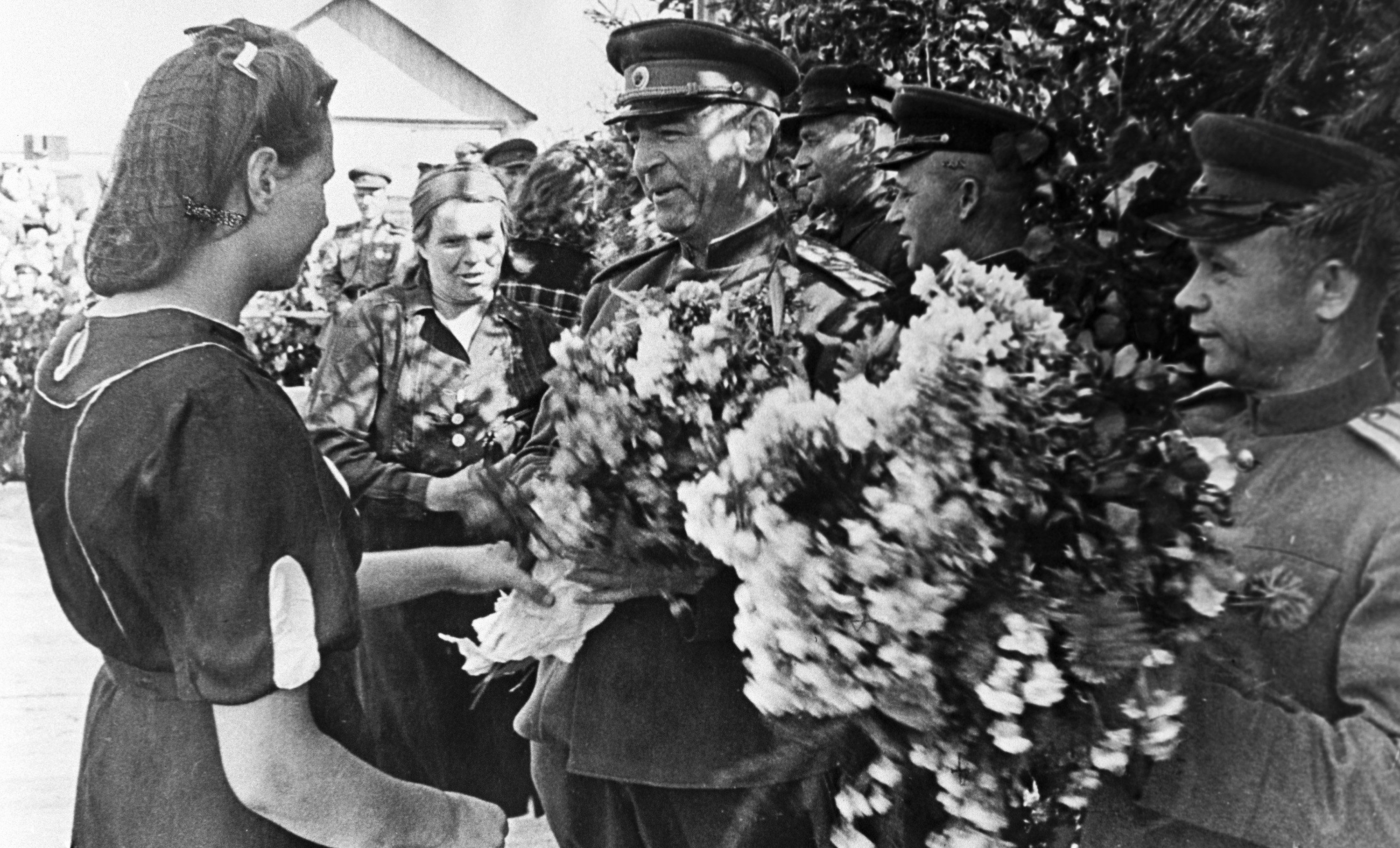 Освобожденные жители латышской деревни преподносят цветы члену Военного Совета II Прибалтийского фронта генерал-лейтенанту Владимиру Николаевичу Богаткину.