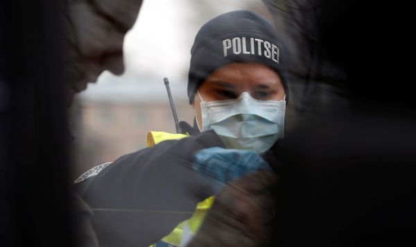 Эстонский полицейский проверяет документы на пограничном пункте пропуска в Валге, Эстония, 17 марта 2020 года