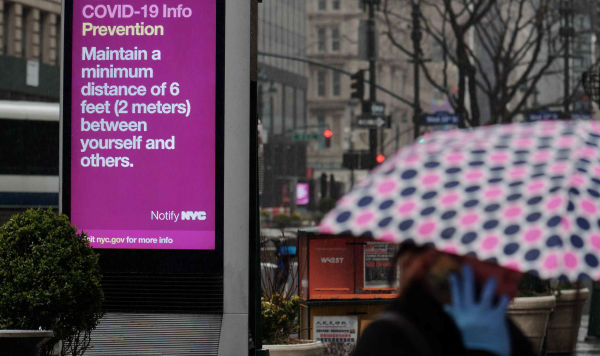Баннер с рекомендацией соблюдать дистанцию с другими людьми, расположенный на Херальд-сквер в Нью-Йорке