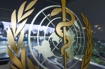 Эмблема ВОЗ на входе в здание штаб-квартиры организации в Женеве 