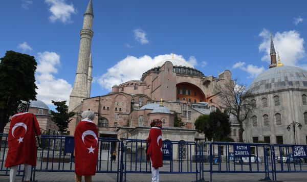 Местные жители с турецкими флагами у собора Святой Софии в Стамбуле, который снова стал мечетью, 10 июля 2020 года
