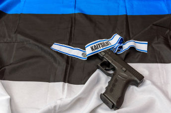Эстонский флаг, пистолет и лента Кайтселийта 