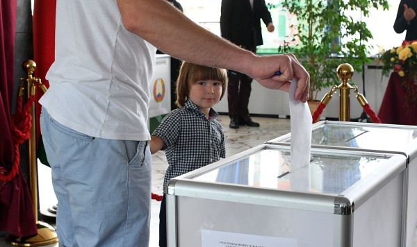 Мужчина голосует на выборах президента Белоруссии на избирательном участке в Минске