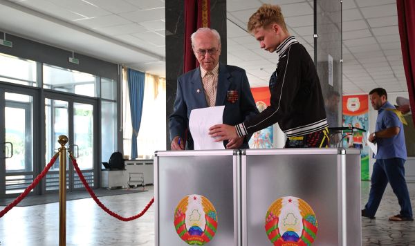 Люди голосуют на выборах президента Белоруссии на избирательном участке в Минске