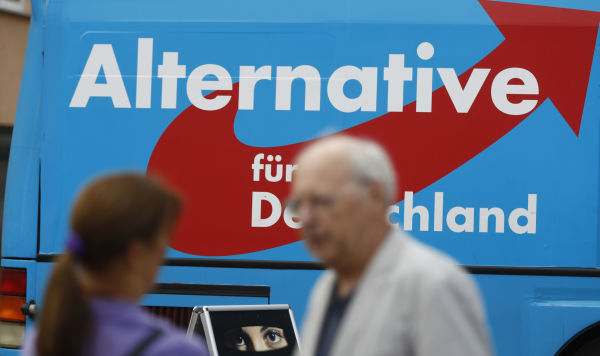 Мужчина и женщина на фоне логотипа партии "Альтернатива для Германии" (АдГ)