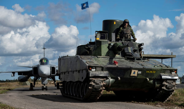 Истребитель JAS-37 и боевая машина пехоты шведских вооруженных сил на острове Готланд
