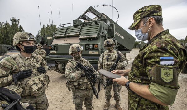 Американские и эстонский военнослужащие во время показательных стрельб из пусковой установки залпового огня MLRS на центральном полигоне Сил обороны Эстонии