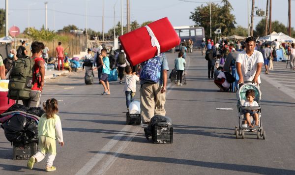 Беженцы и мигранты из разрушенного лагеря Мориа движутся к новому временному лагерю на острове Лесбос