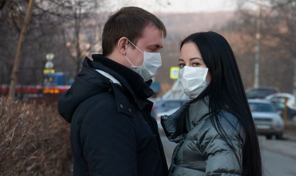 Молодой человек и девушка в медицинских масках