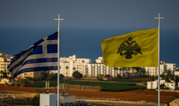 Флаги Греции (слева) и Греческой православной церкви в городе Протарас на Кипре