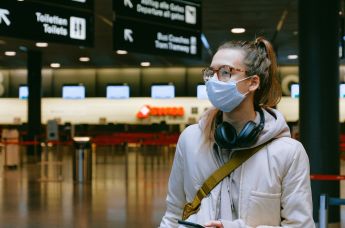 Девушка в медицинской маске в аэропорту