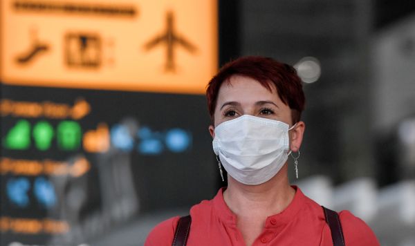 Пассажир в медицинской маске в аэропорту