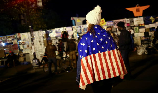Женщина с флагом США возле Белого дома в день выборов в Вашингтоне