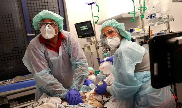 Врач и парамедик реанимируют пациента с коронавирусом