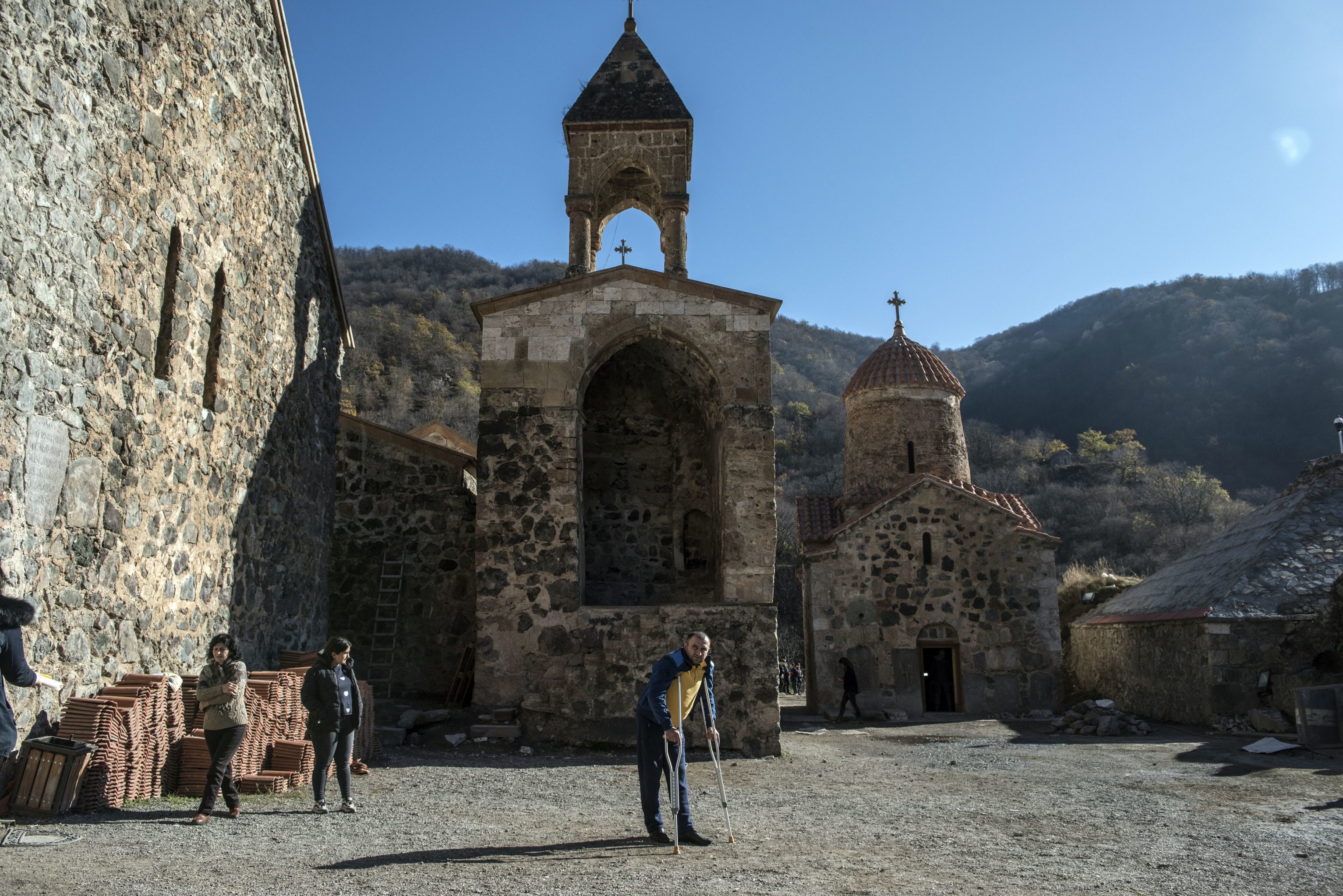 Мужчина на костылях в монастыре Дадиванк в Кельбаджарском районе Нагорного Карабаха