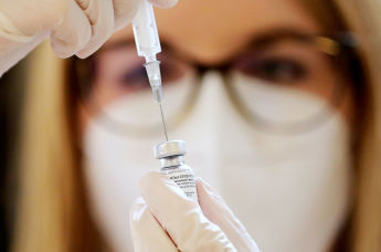 Медицинский работник готовит шприц для введения вакцины от коронавируса Pfizer-BioNTech
