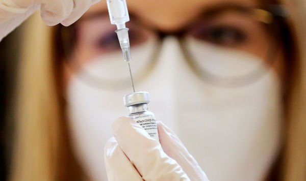 Медицинский работник готовит шприц для введения вакцины от коронавируса Pfizer-BioNTech
