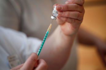 Медицинский работник готовит дозу вакцины Pfizer-BioNTech в центре вакцинации от коронавируса 