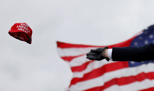 Президент США Дональд Трамп бросает кепку с надписью "Сделаем Америку снова великой"