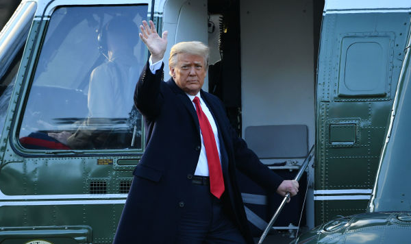 Уходящий президент США Дональд Трамп машет рукой с борта вертолета около Белого дома в Вашингтоне