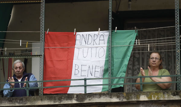 Coppia di anziani sul balcone con la bandiera dell'Italia con la scritta "Andrà tutto bene" a Roma