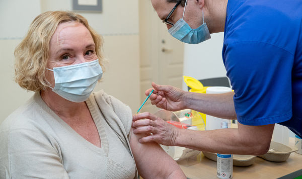 Женщина проходит процедуру вакцинирования от COVID-19