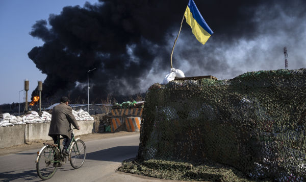 Мужчина едет на велосипеде на окраине Киева