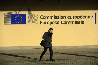 Мужчина идет перед зданием комиссии Европейского союза в Брюсселе