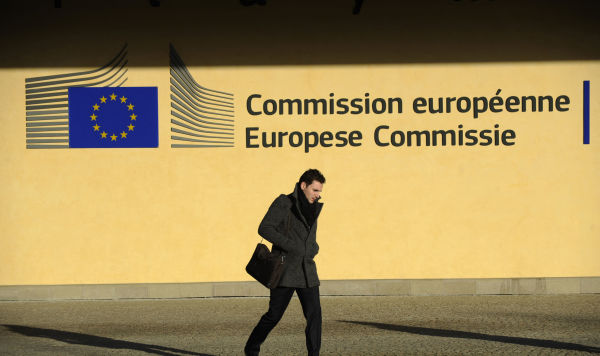 Мужчина идет перед зданием комиссии Европейского союза в Брюсселе