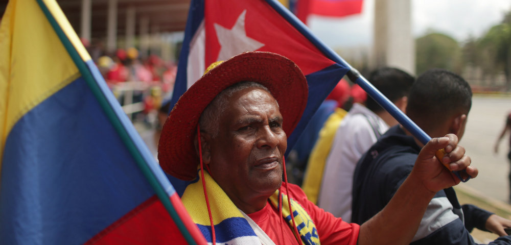 Житель Каракаса с национальными флагами в руках