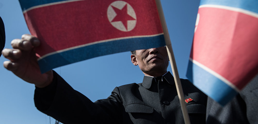Жители Пхеньяна с флагами КНДР