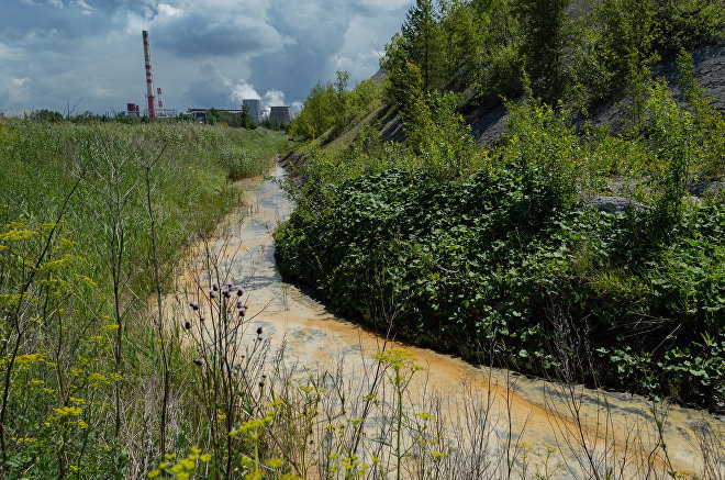 Желтая вода в отводной канаве. Индустриальный пейзаж на окраине Кохтла-Ярве 