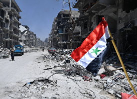 Флаг Сирии в освобожденном лагере палестинских беженцев "Ярмук" на юге Дамаска