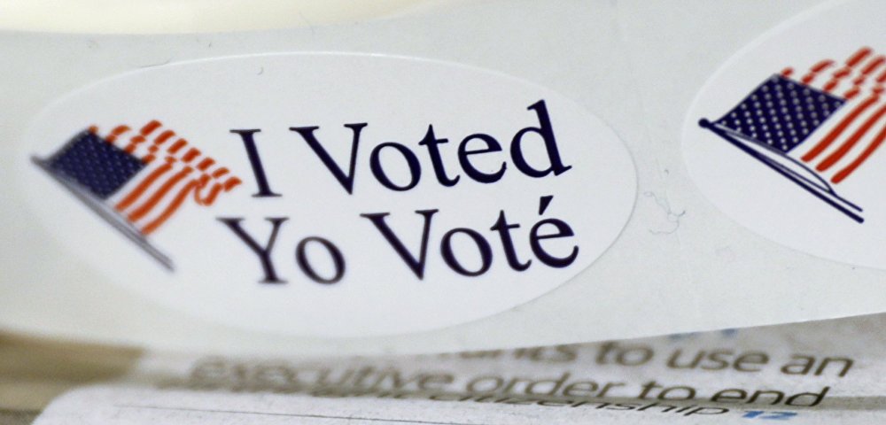 Наклейки "Я проголосовал" на столе во время голосования в публичной библиотеке города Вашингтона