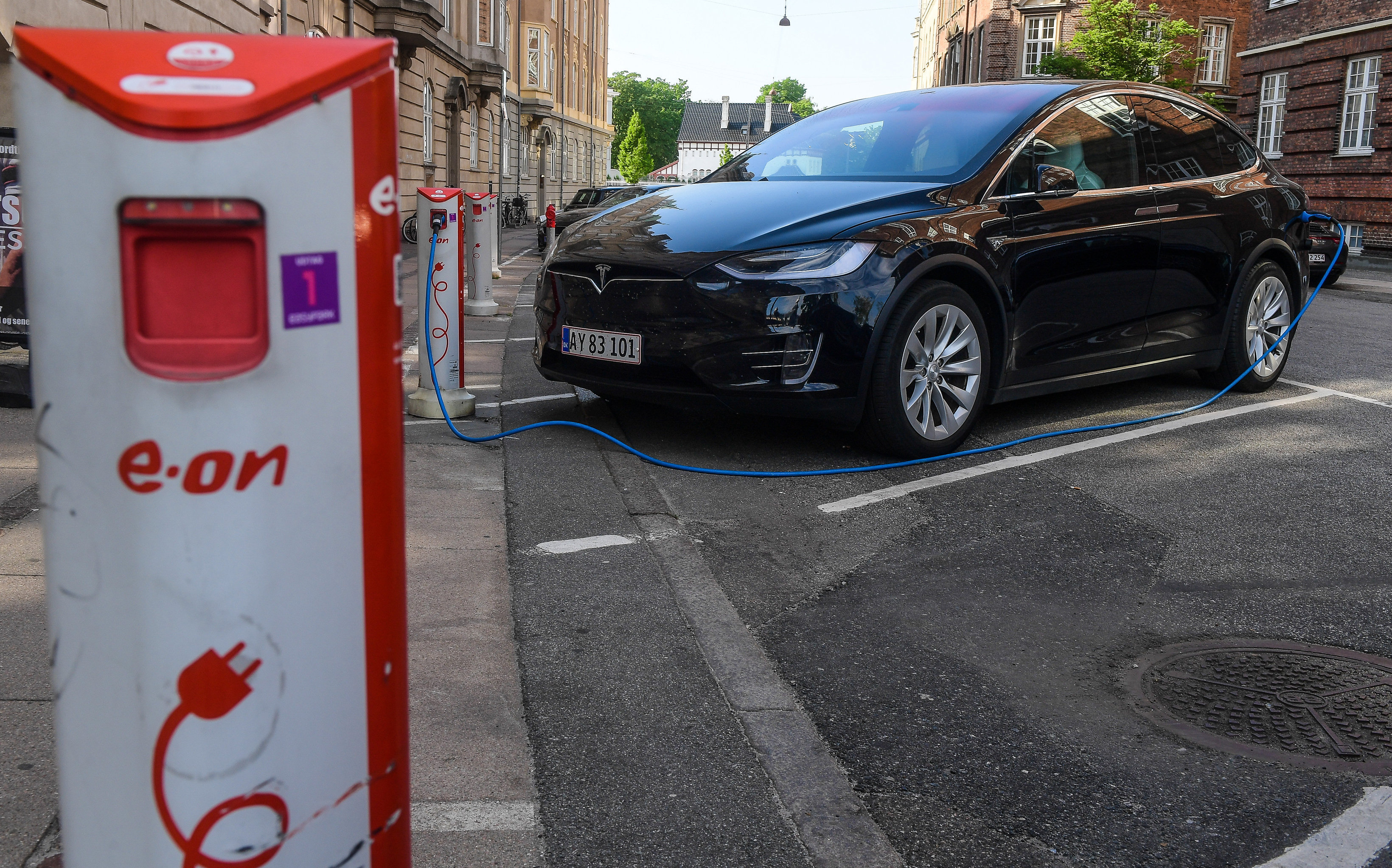 Дания, Копенгаген. Зарядка электромобиля Tesla на одной из улиц города.